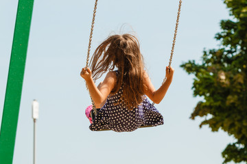 Girl swinging on swing-set.