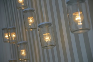 Vintage decorative jar lights on wall and stripped wallpapers