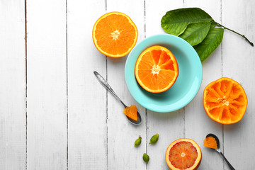 Eating oranges with spoon on white wooden table
