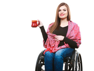 Woman invalid girl on wheelchair holds tea mug