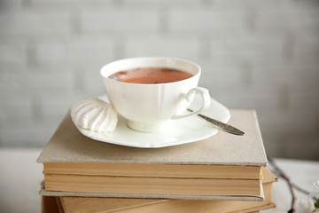 Cup of tea and books on wooden table
