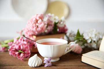 Cup of tea and flowers on wooden table