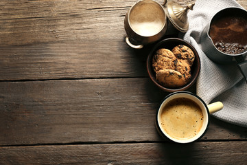 Mug of coffee with cookies on wooden table