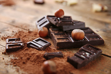 Slices of dark chocolate with nuts on table