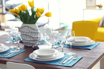 Table served with dishes and a bouquet of tulips