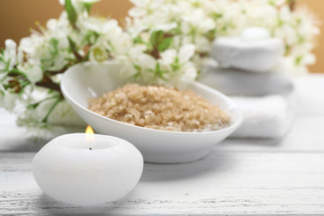 Spa treatment with blooming branch on white wooden table
