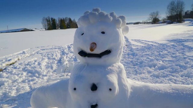 The spiked hair of the snowman on a thick covered ground in the village