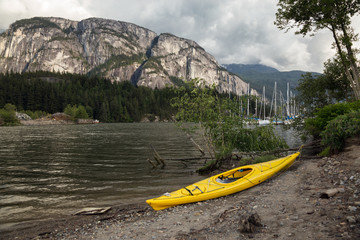 Kayak by the river, with Chief Mountain in the background on a cloudy day. Taken in Squamish, British Columbia, Canada