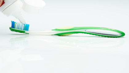 putting tooth paste on brush