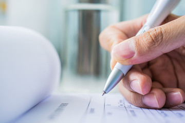 Hand with pen over application form