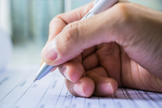 Hand with pen over application form