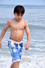 Fototapeta na wymiar Boy playing on the ocean beach