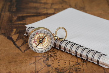 Compass with note book on old map vintage process style