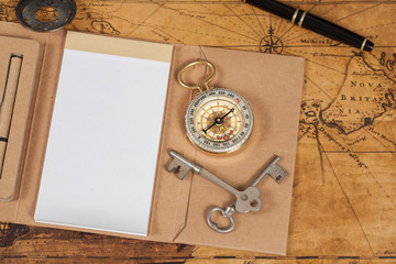 Compass with note book on old map vintage process style