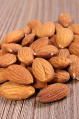 Heap of almonds on wooden background