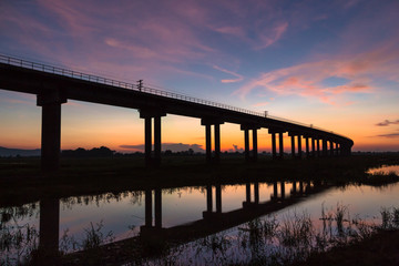 Obraz premium A train is crossing bridge at Pa Sak Jolasid Dam, Thailand in sunset time