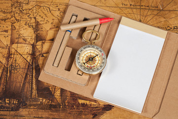 Compass with note book on old map vintage process style