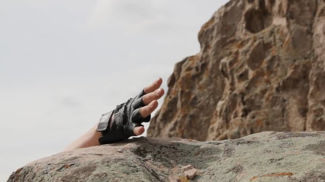 Climber on edge of cliff serves a helping hand