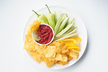 beet hummus in bowl on white background.