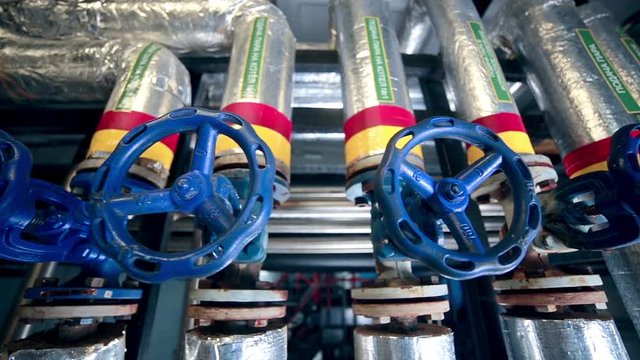 Valves, pipes, gauges at a Gas and oil production plant. Slider shot. HD.