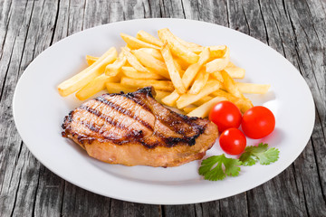 grilled pork chops on a white dish, close-up