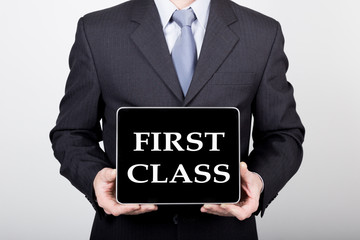 technology, internet and networking in business concept - businessman holding a tablet pc with first class sign. Internet technologies in business