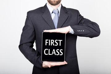 technology, internet and networking in business concept - businessman holding a tablet pc with first class sign. Internet technologies in business