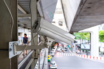 Close up CCTV security camera with blur of traffic jam in the background