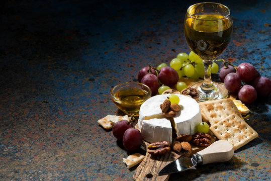 Camembert cheese, snacks and a glass of white wine