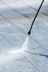 Using a pressure hose to power clean paving