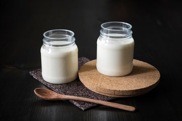 natural yogurt in a jar on the dark background
