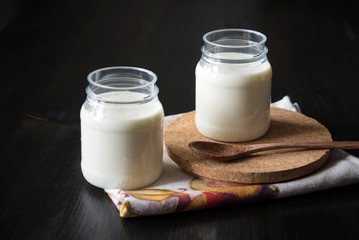natural yogurt in a jar on the dark background