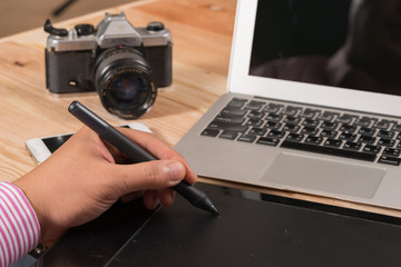 Graphic designer using digital tablet and computer in the office
