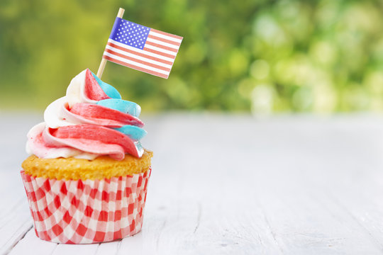 Cupcake with red-white-and-blue frosting and an American flag