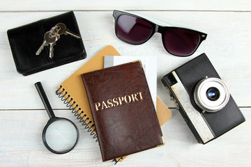 a passport with a camera and a ticket on a white wooden background with a Notepad and other things. A set of travel items