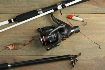 new spinning reel with a bait and hook on a brown wooden background