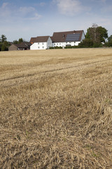 Fototapeta na wymiar Stoppelfeld mit Bauernhof, Kamen, Nordrhein-Westfalen, Deutschland