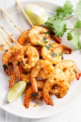  grilled shrimp kababs with sriracha and lime. © shersor