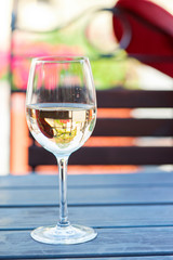 Glass of delicious fresh white wine on summer terrace. Outdoors.