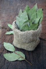 aromatic dry bay leaf in sackcloth and bay leaf on wooden board. dry herb