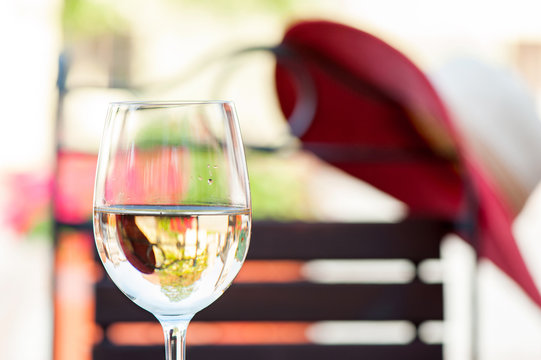 Glass of delicious fresh white wine on summer terrace. Outdoors.