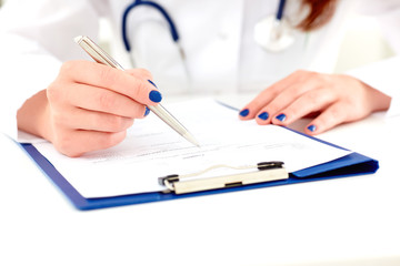 Female medicine doctor hand holding silver pen writing something