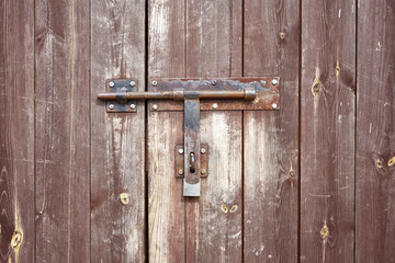 Old metal hasp on old wooden door.