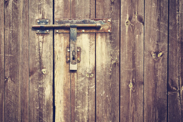 Vintage stylized old metal hasp on wooden door.