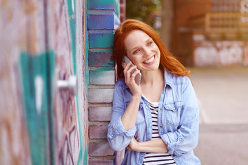 Fototapeta premium lächelnde frau telefoniert mit ihrem mobiltelefon