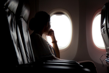 Fototapeta premium woman looks out the window of an airplane