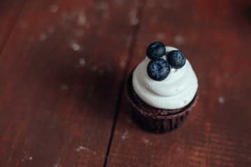  vanila cupcake with blueberry on wooden table