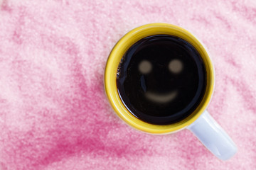Coffee pink with a cup smiley on sugar background.