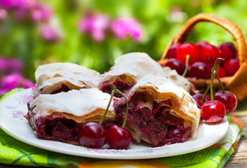 Berries strudel with icing sugar and sour cherries