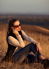Fashionable,beautiful,glamour,stylish,sexy,young,elegant,hot,sunny,nice,colorful girl with wonderful sunglasses,black vest outdoors on the hill with a beautiful look in the summer,good time,sex,sunny